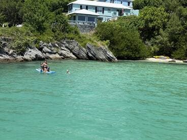 A fun day on the water with a group paddleboarding and swimming in the clear turquoise waters, perfect for family adventures and beach outings.