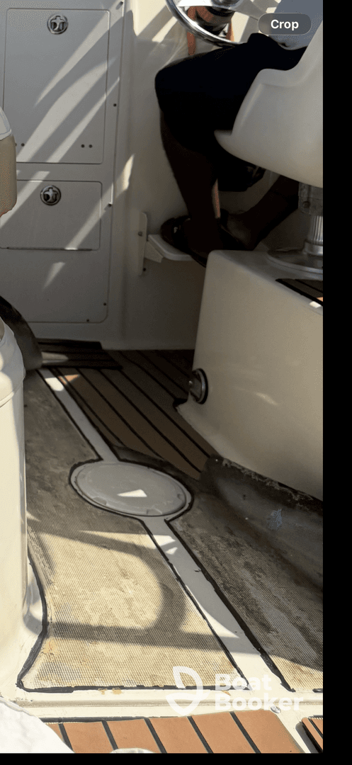 A glimpse of the interior helm area of a boat, showcasing the seating and control panel, perfect for navigating the waters.