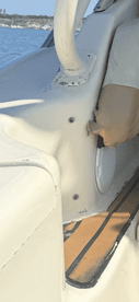 Interior view of a boat's seating area, showcasing the helm and upholstery details, ideal for comfortable cruising.