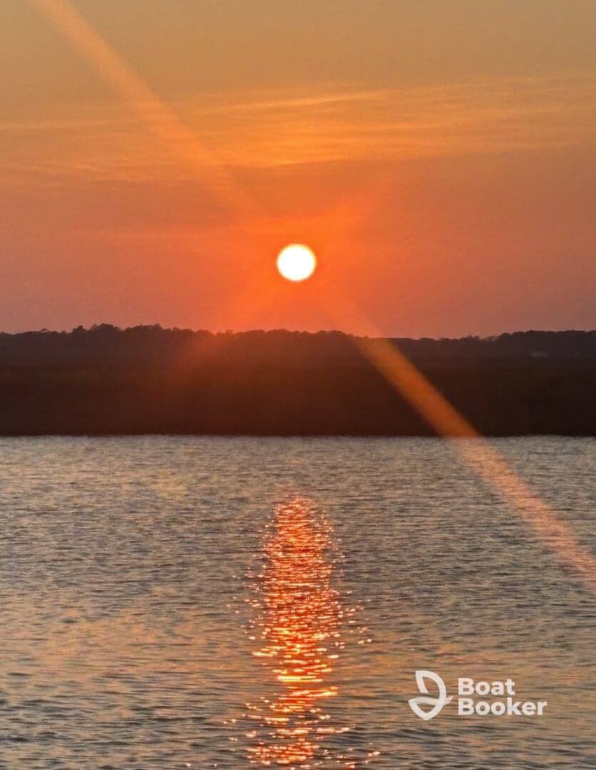 A stunning sunset casts a warm glow over the water, creating a beautiful reflection — perfect for capturing serene moments on the water.