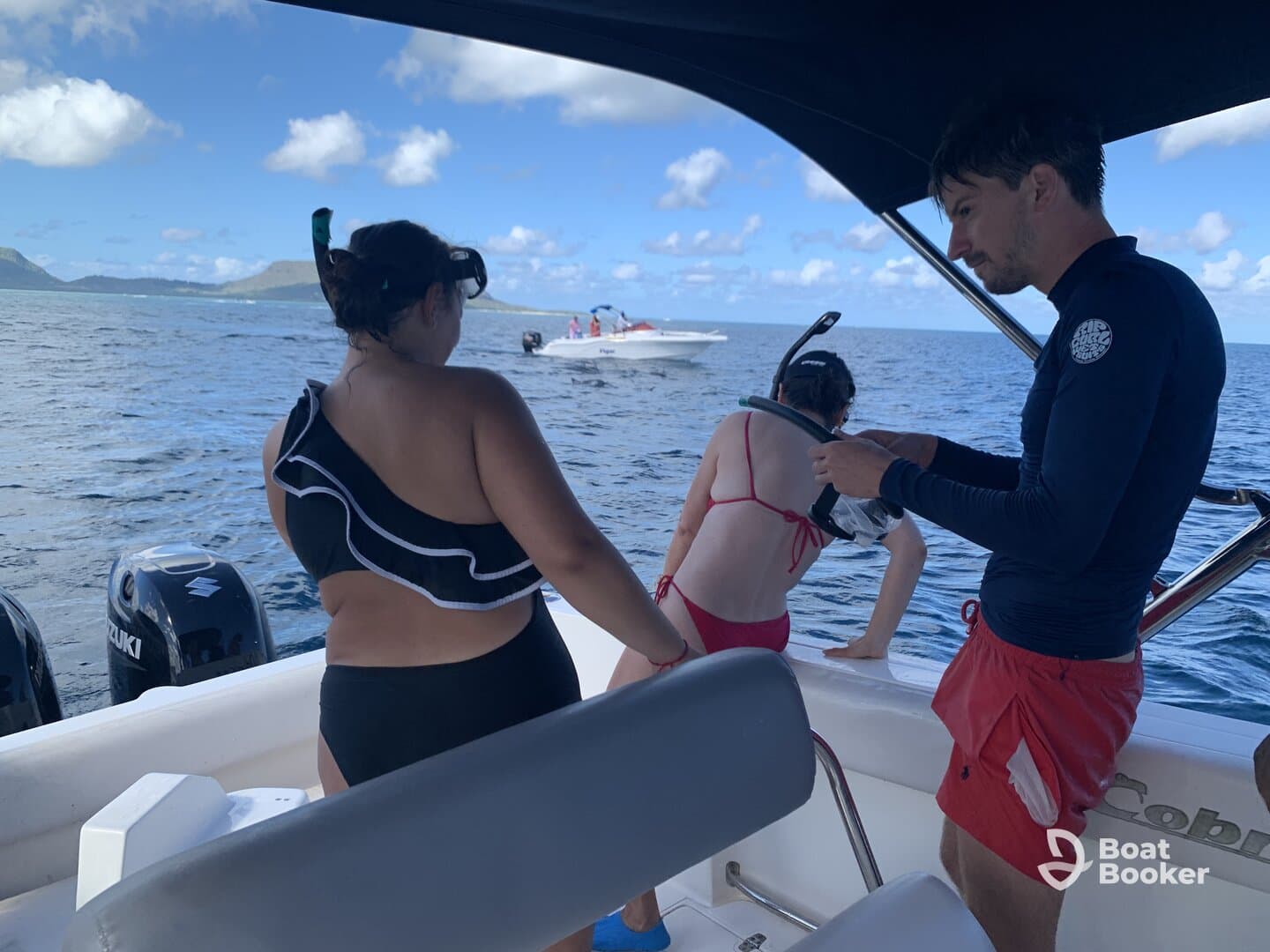 A group prepares for snorkeling off the side of a boat, showcasing the excitement of ocean adventures and water activities.