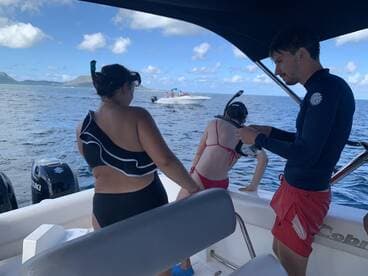 A group prepares for snorkeling off the side of a boat, showcasing the excitement of ocean adventures and water activities.