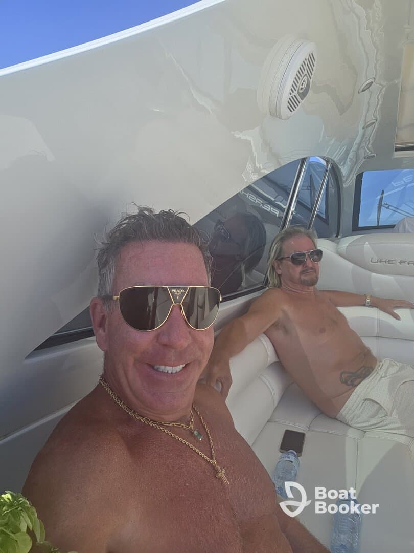 Two men relax on the deck of a boat, enjoying the sun and each other's company — a perfect moment for leisure on the water.
