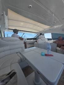 Inside view of a luxurious boat cabin featuring comfortable seating and helm area, perfect for relaxing while cruising on the water.
