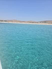 A scenic view of clear turquoise waters and a distant shoreline, capturing the serene beauty of a coastal landscape.