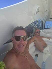 Two men relax on the deck of a boat, enjoying the sun and each other's company — a perfect moment for leisure on the water.