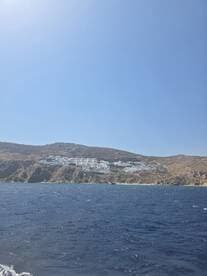 A stunning view of a coastal hillside with white buildings, showcasing the beautiful scenery of the island — perfect for travelers seeking picturesque destinations.