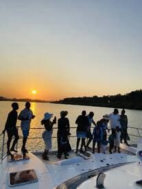 A joyful family gathers on the deck of a boat at sunset, capturing memories against a stunning backdrop — perfect for celebrations and family outings on the water.