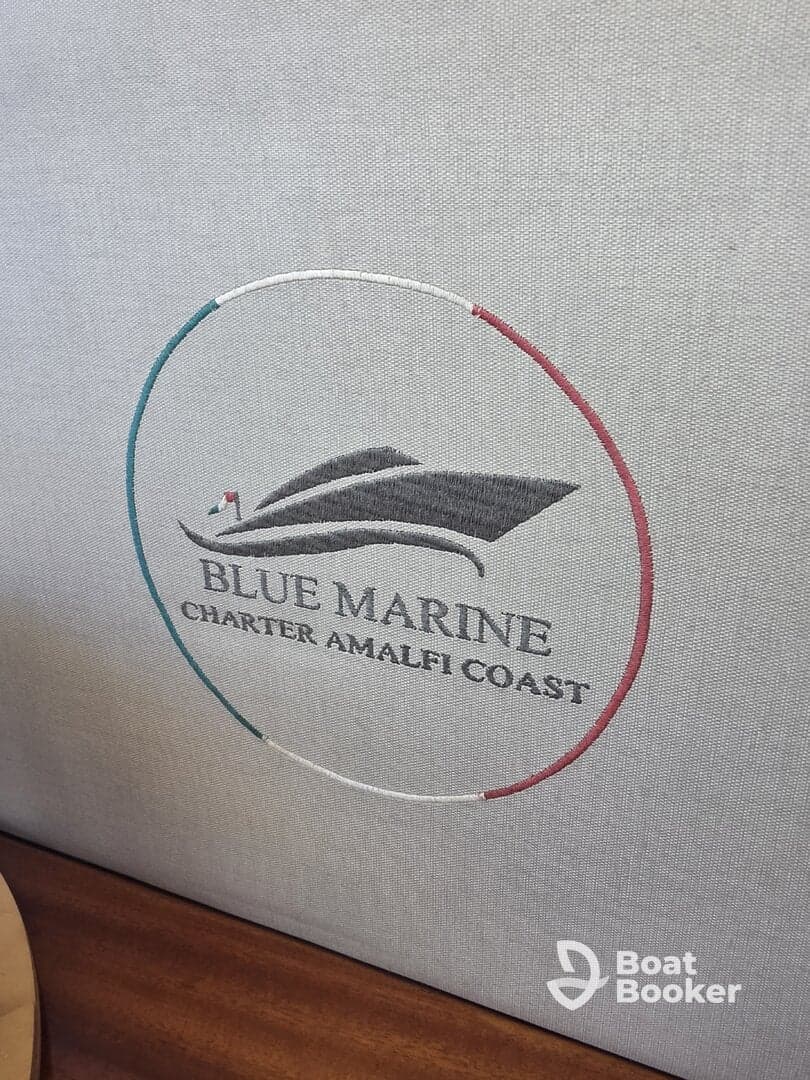Close-up of the embroidered logo for Blue Marine Charter Amalfi Coast, showcasing the elegant branding on the boat's interior.