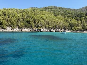 A stunning view of turquoise waters and lush greenery along the coastline, showcasing a serene boating destination perfect for relaxation and exploration.