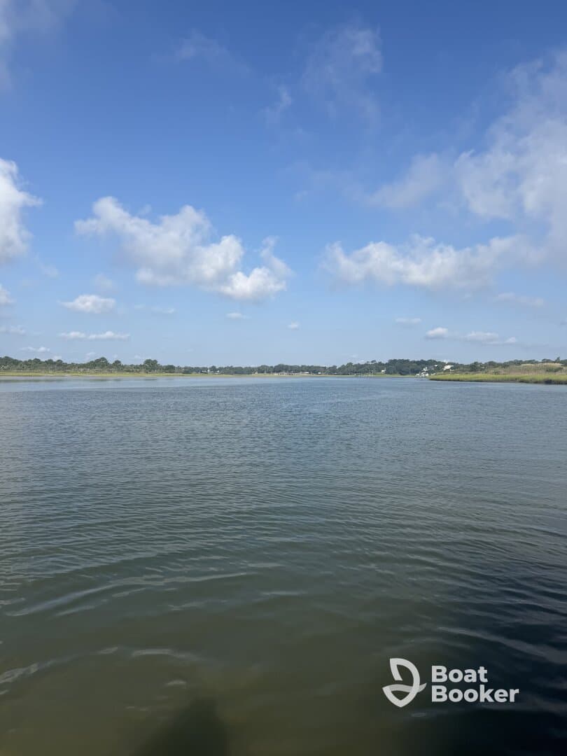 A scenic view of a calm waterway under a clear blue sky, ideal for boating or nature exploration.