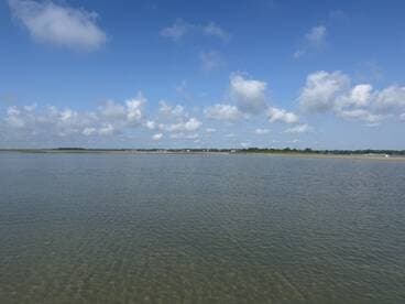 A scenic view of calm waters and a cloudy sky, capturing the tranquility of the landscape.