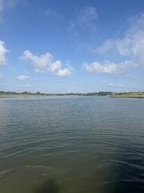 A scenic view of a calm waterway under a clear blue sky, ideal for boating or nature exploration.