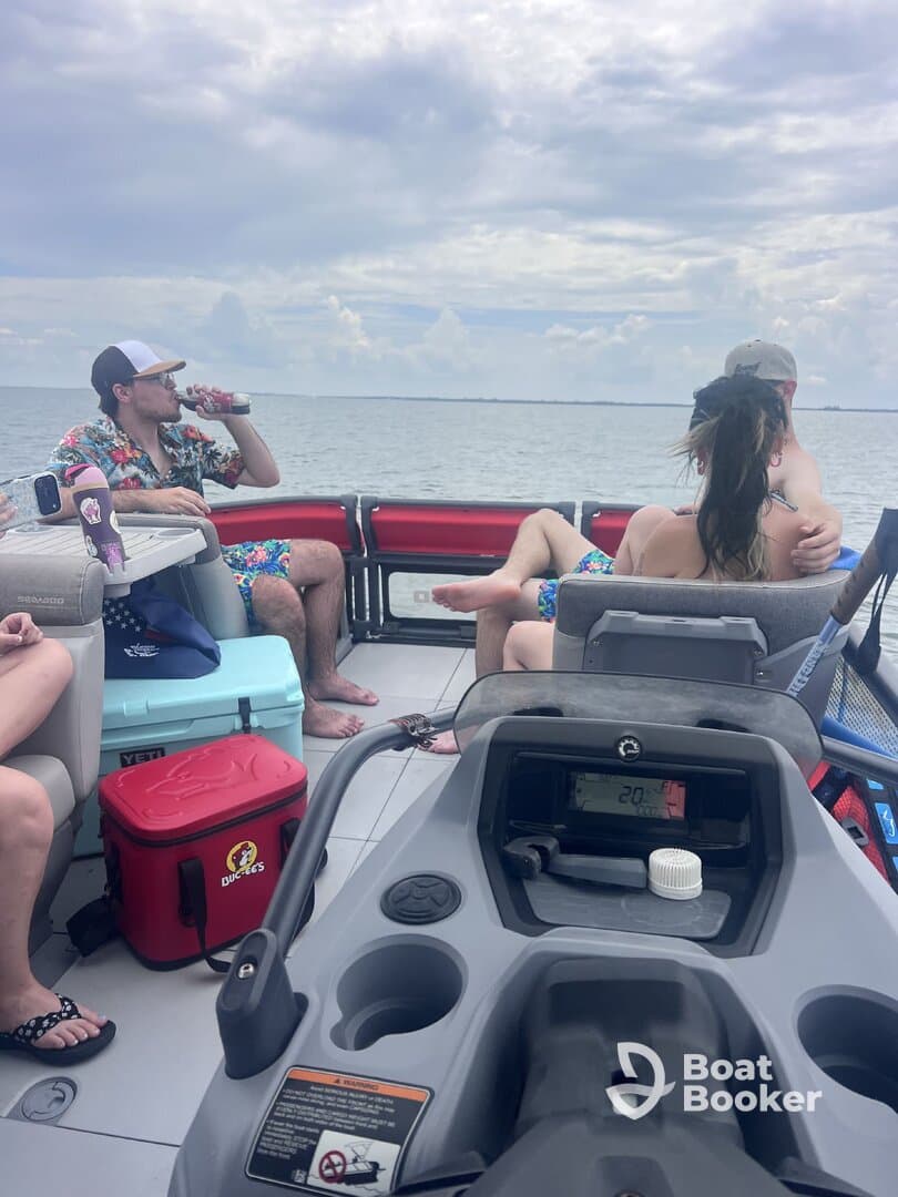 A lively group enjoys drinks aboard a pontoon boat, capturing the essence of a fun day on the water with friends.