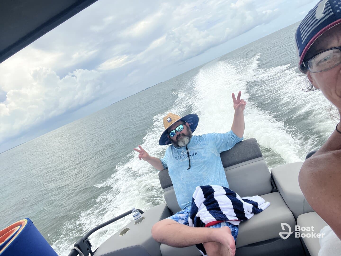 A man relaxes on a boat, flashing a peace sign while enjoying a day on the water — perfect for capturing fun moments during a boating adventure.