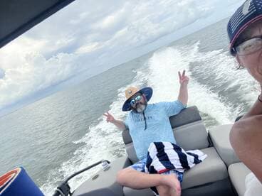 A man relaxes on a boat, flashing a peace sign while enjoying a day on the water — perfect for capturing fun moments during a boating adventure.
