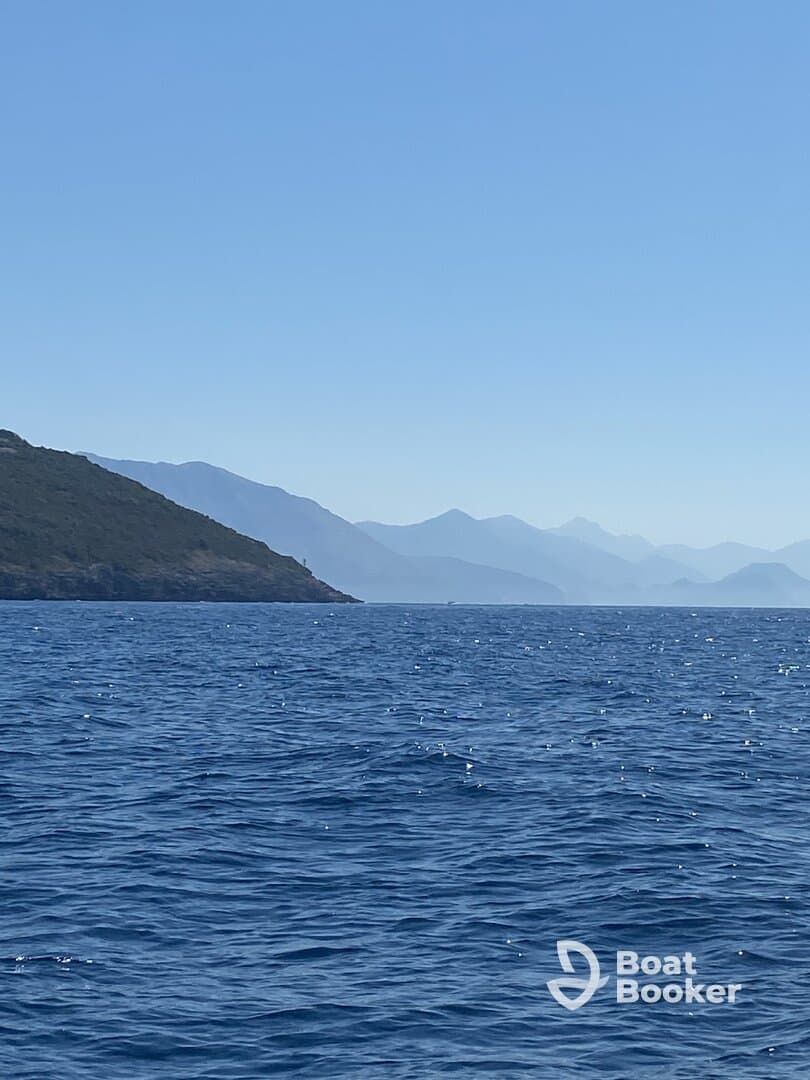 A stunning view of a serene coastline with distant mountains, capturing the beauty of the open water and perfect for nature lovers and adventure seekers.