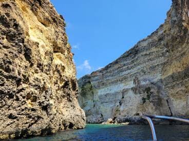 A stunning view of dramatic rock formations along the coastline, showcasing the natural beauty of the area — perfect for scenic boat tours.