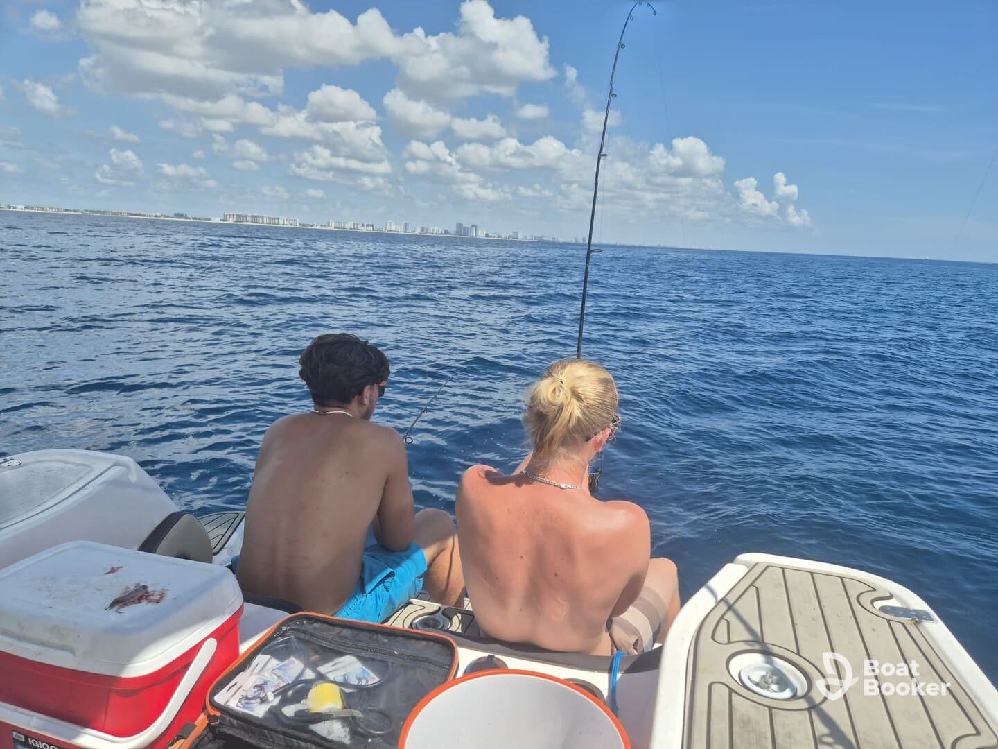A couple enjoys a fishing trip on the open water, casting their lines into the deep blue sea — a perfect day for fishing enthusiasts.