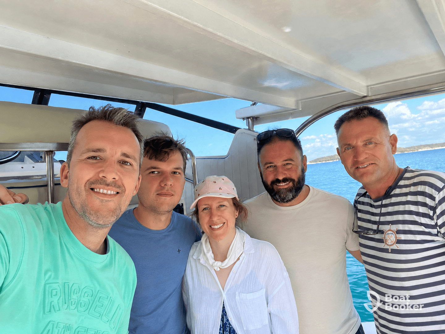 A cheerful group of friends poses for a selfie aboard a boat, enjoying their time on the water — perfect for memorable outings and adventures.