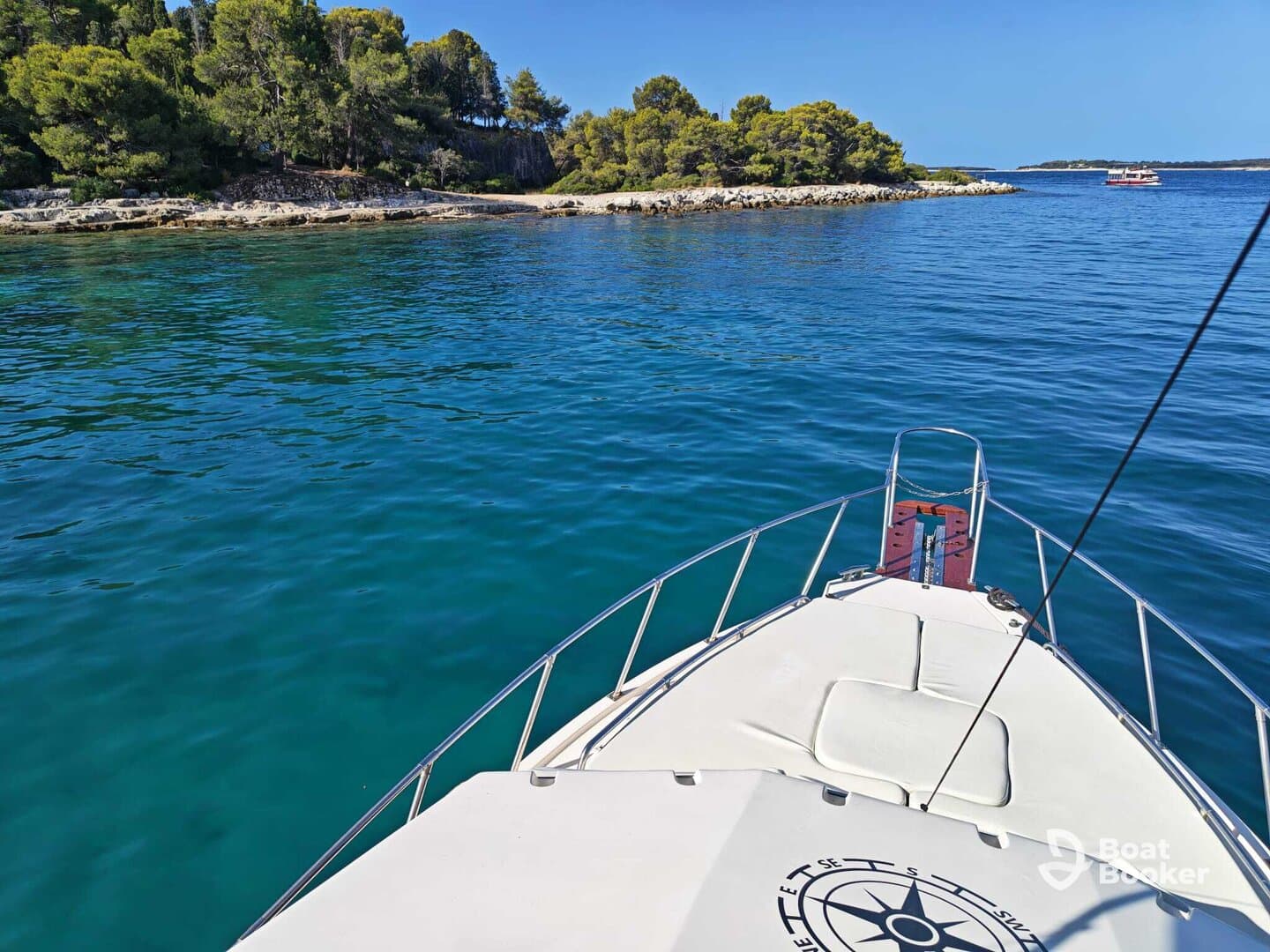 A stunning view from the front of a boat cruising through crystal-clear waters, surrounded by lush greenery and rocky shores — perfect for exploring coastal destinations.