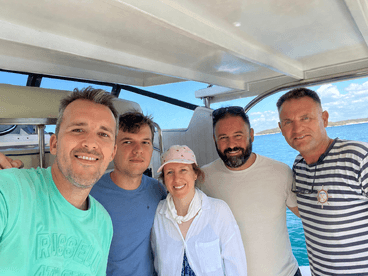 A cheerful group of friends poses for a selfie aboard a boat, enjoying their time on the water — perfect for memorable outings and adventures.