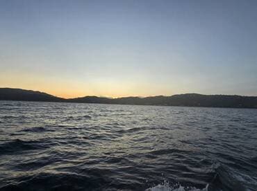 A serene sunset view over the water, showcasing the tranquil beauty of nature — perfect for peaceful evening boat rides.