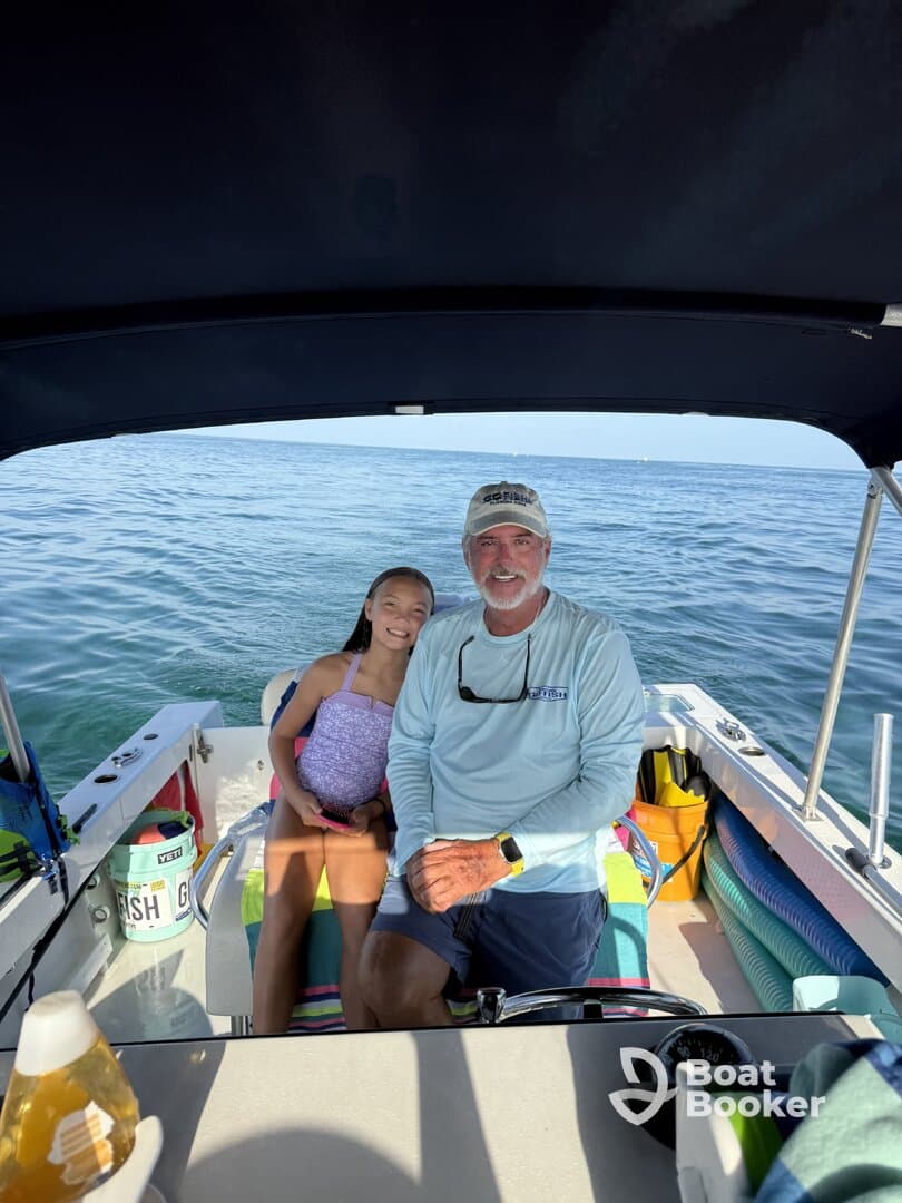 A joyful moment captured aboard a boat, featuring a smiling adult and a child enjoying their time on the water — perfect for family outings and memorable adventures.