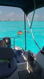 A fun day on the water as two children float in a tube while enjoying the vibrant turquoise waters — perfect for family adventures and summer outings.