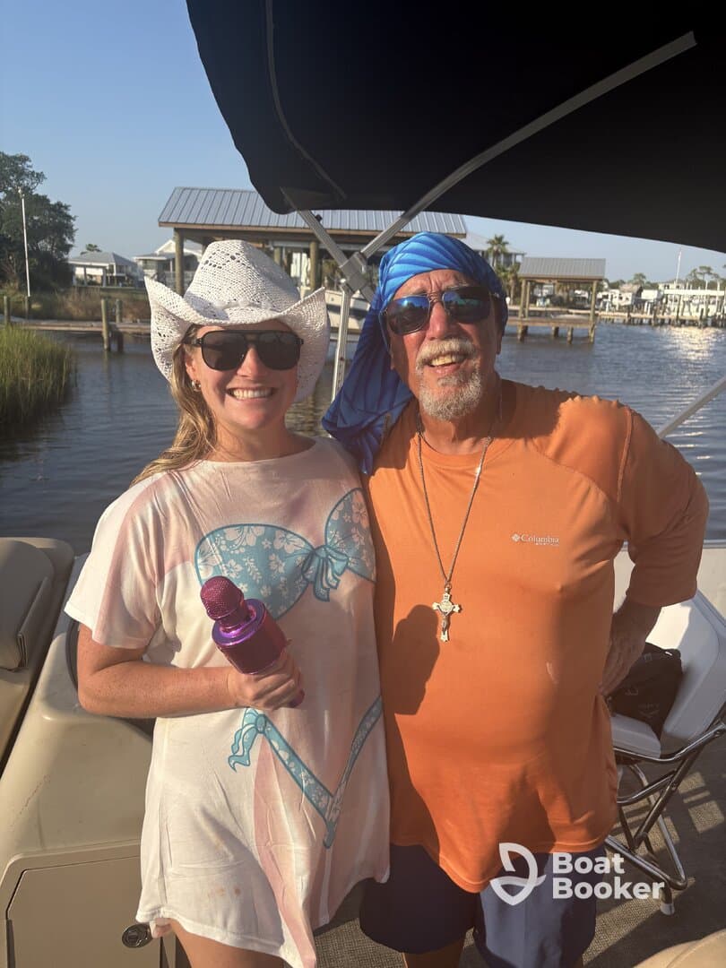 A cheerful duo poses for a photo on a boat, capturing a moment of friendship and fun on the water.