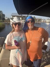 A cheerful duo poses for a photo on a boat, capturing a moment of friendship and fun on the water.