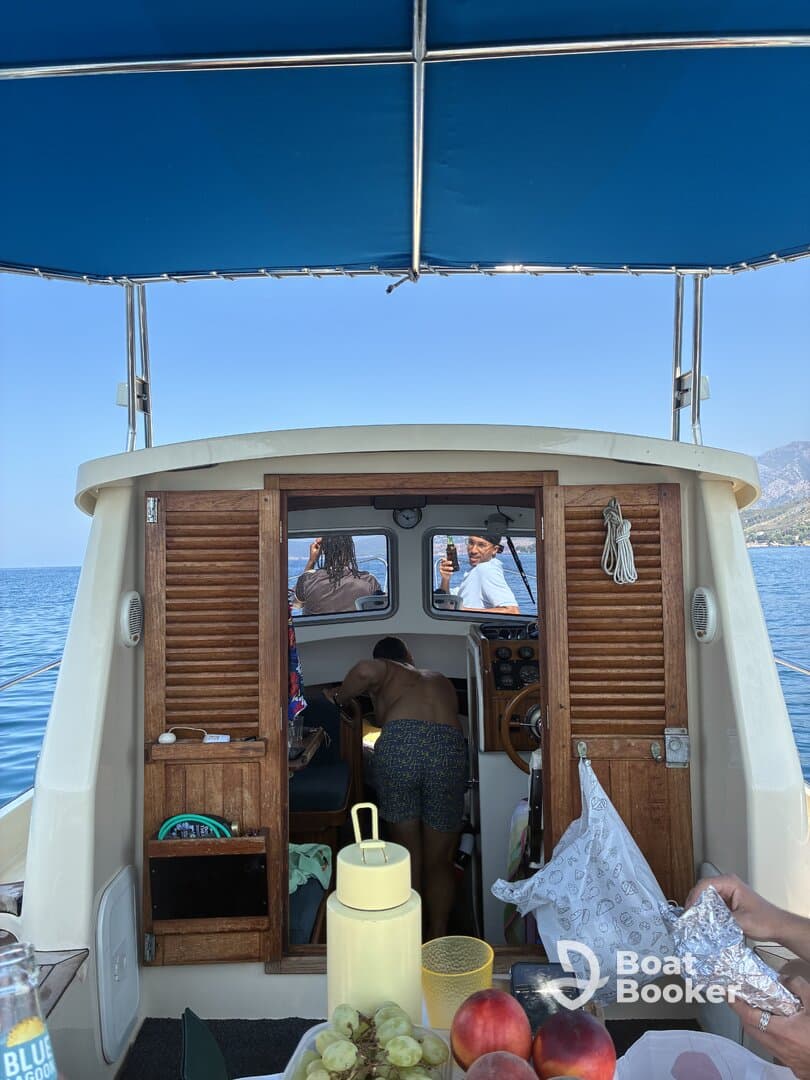 A lively scene inside a boat with guests enjoying food and drinks, showcasing a fun and social atmosphere on the water.