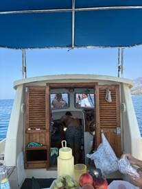 A lively scene inside a boat with guests enjoying food and drinks, showcasing a fun and social atmosphere on the water.
