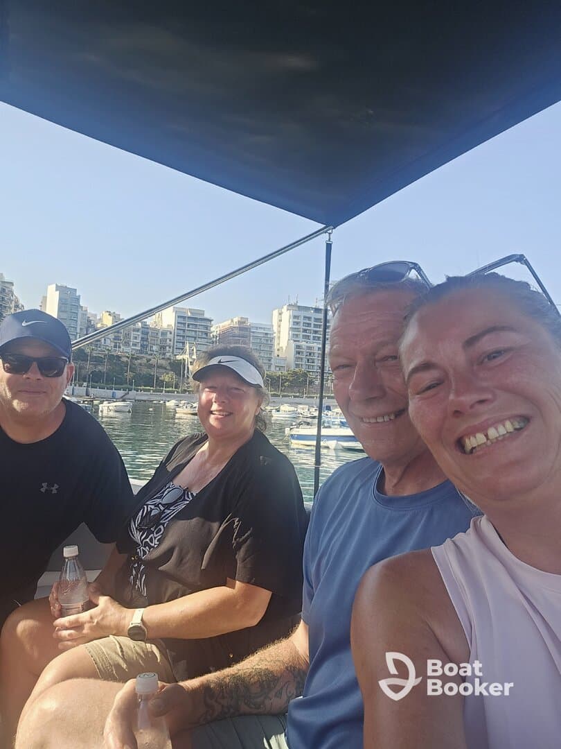 A cheerful group enjoys a day on the boat, capturing a fun moment together against a scenic marina backdrop.