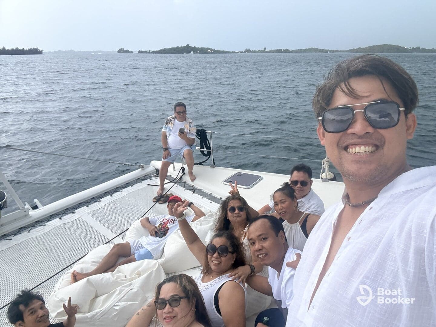 A lively group of friends enjoys a day on a pontoon boat, capturing memories with smiles and laughter against a scenic backdrop of water and islands.