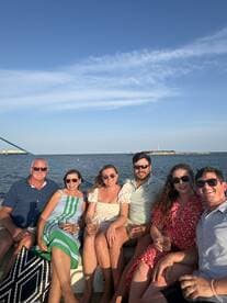 A cheerful group enjoys cocktails aboard a boat, capturing the essence of a perfect sunset cruise with friends.