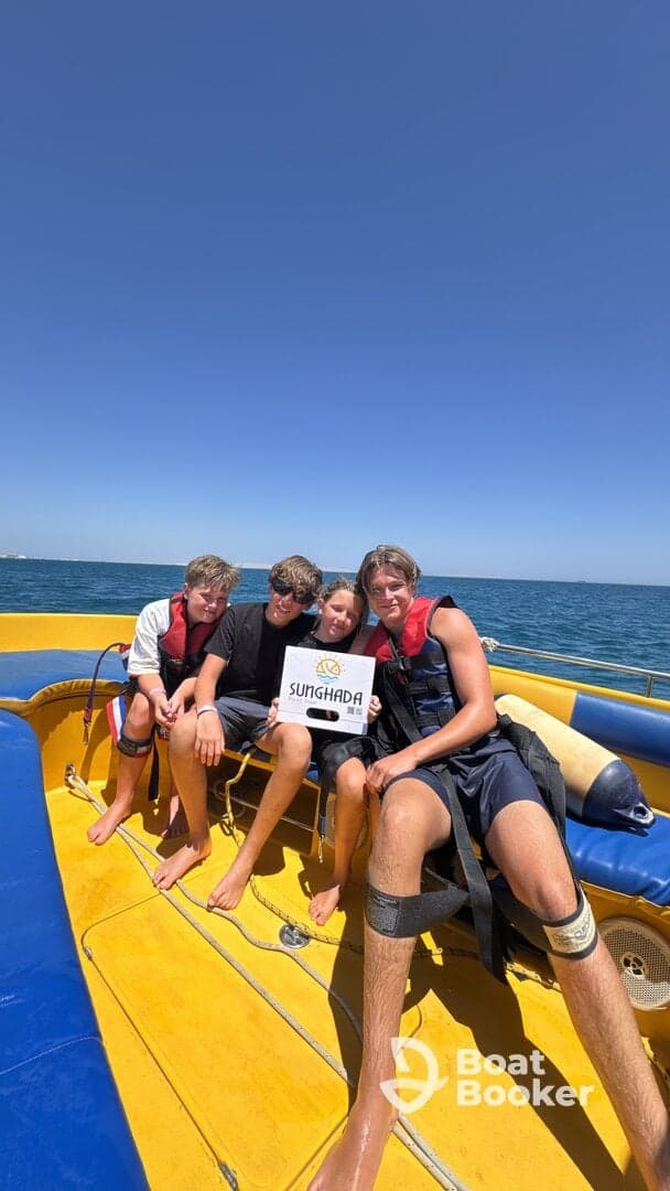 A cheerful group of kids poses on a boat, showcasing their excitement for a fun day on the water — perfect for family adventures and water sports.
