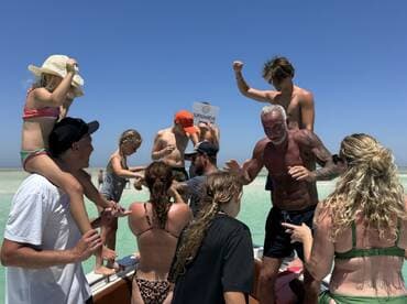 A lively group of family and friends enjoys a fun day on the water, celebrating and playing together on a boat — perfect for memorable summer outings.
