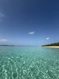A stunning view of crystal-clear turquoise waters and a serene beach, perfect for showcasing the beauty of tropical destinations.