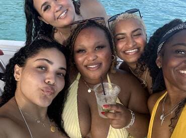 A joyful group of friends enjoys cocktails together on a boat, capturing the essence of a fun day on the water.