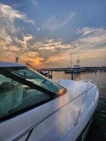 A stunning side view of a yacht docked at sunset, showcasing the serene marina atmosphere and beautiful sky.