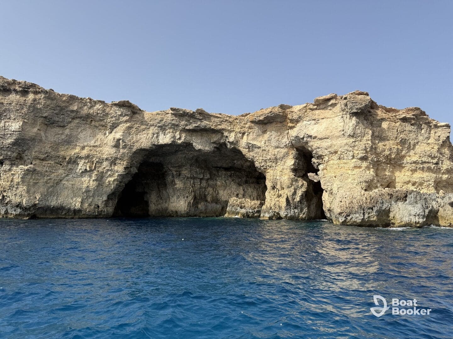 A stunning view of coastal caves along the shoreline, showcasing the natural beauty of the landscape — perfect for exploring and sightseeing during boat trips.