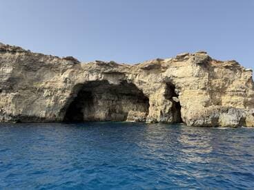 A stunning view of coastal caves along the shoreline, showcasing the natural beauty of the landscape — perfect for exploring and sightseeing during boat trips.