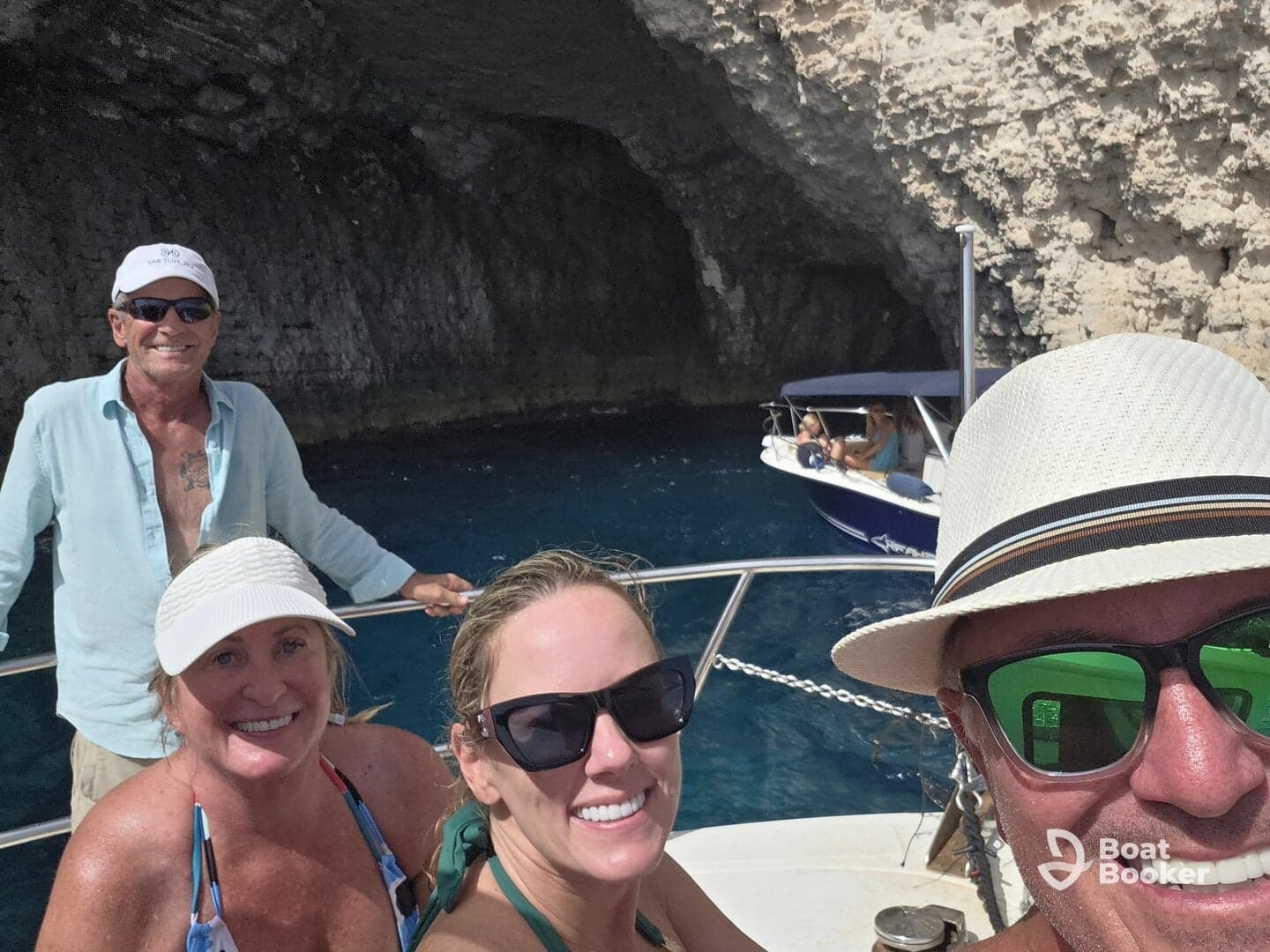 A cheerful group enjoys a boat trip near a stunning cave, capturing a memorable moment together — perfect for adventure seekers and nature lovers.