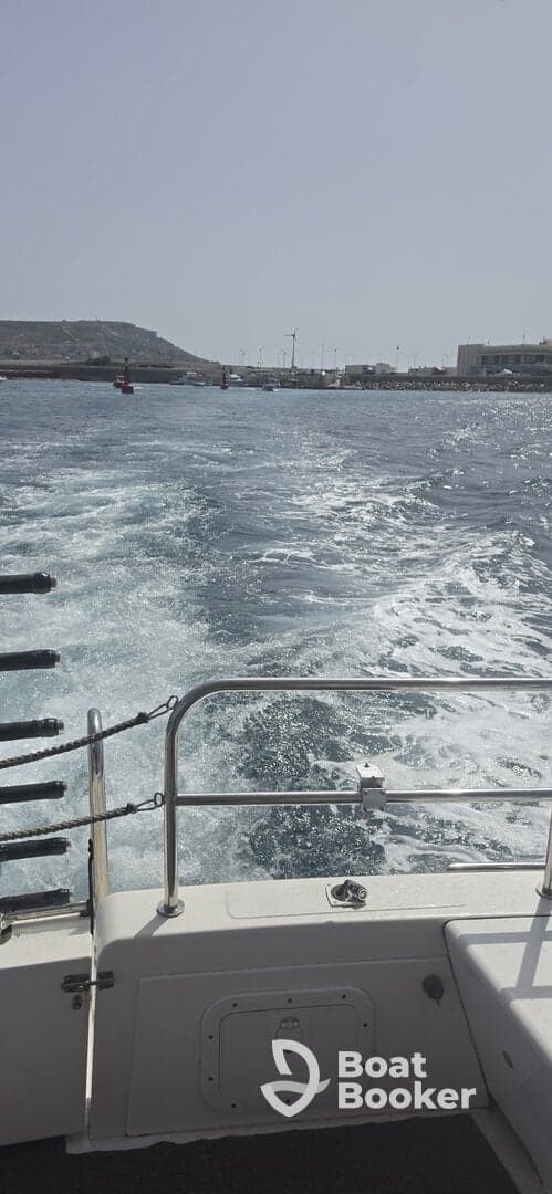 A view from the deck of a boat as it moves through the water, showcasing the wake and surrounding harbor scenery.
