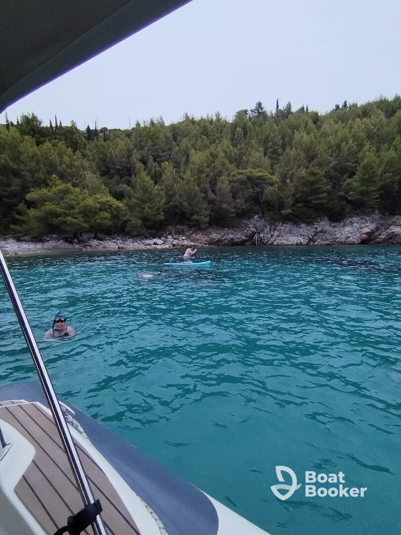 Guests enjoy snorkeling and swimming in the stunning turquoise waters, surrounded by lush greenery — a perfect day for aquatic adventures.