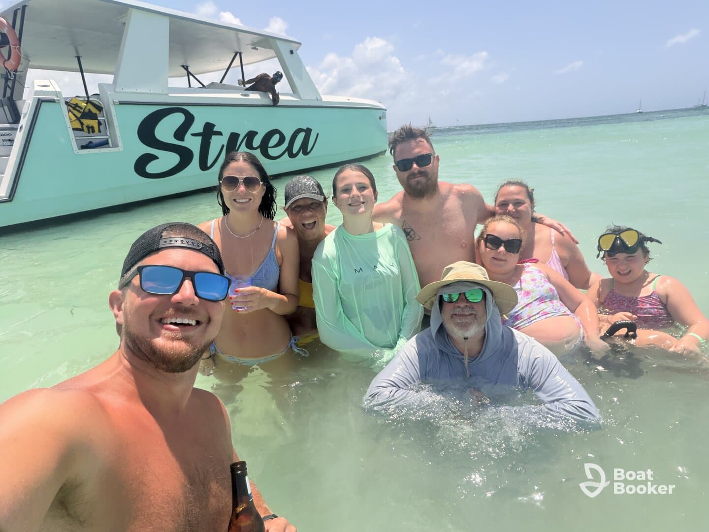 A joyful group enjoys a fun day in the water next to the 'Strea' pontoon boat, creating unforgettable memories under the sun.