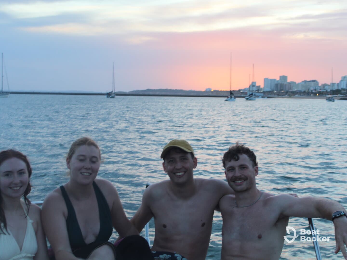 A cheerful group enjoys a sunset moment on the water, capturing the essence of a perfect boating experience with friends.