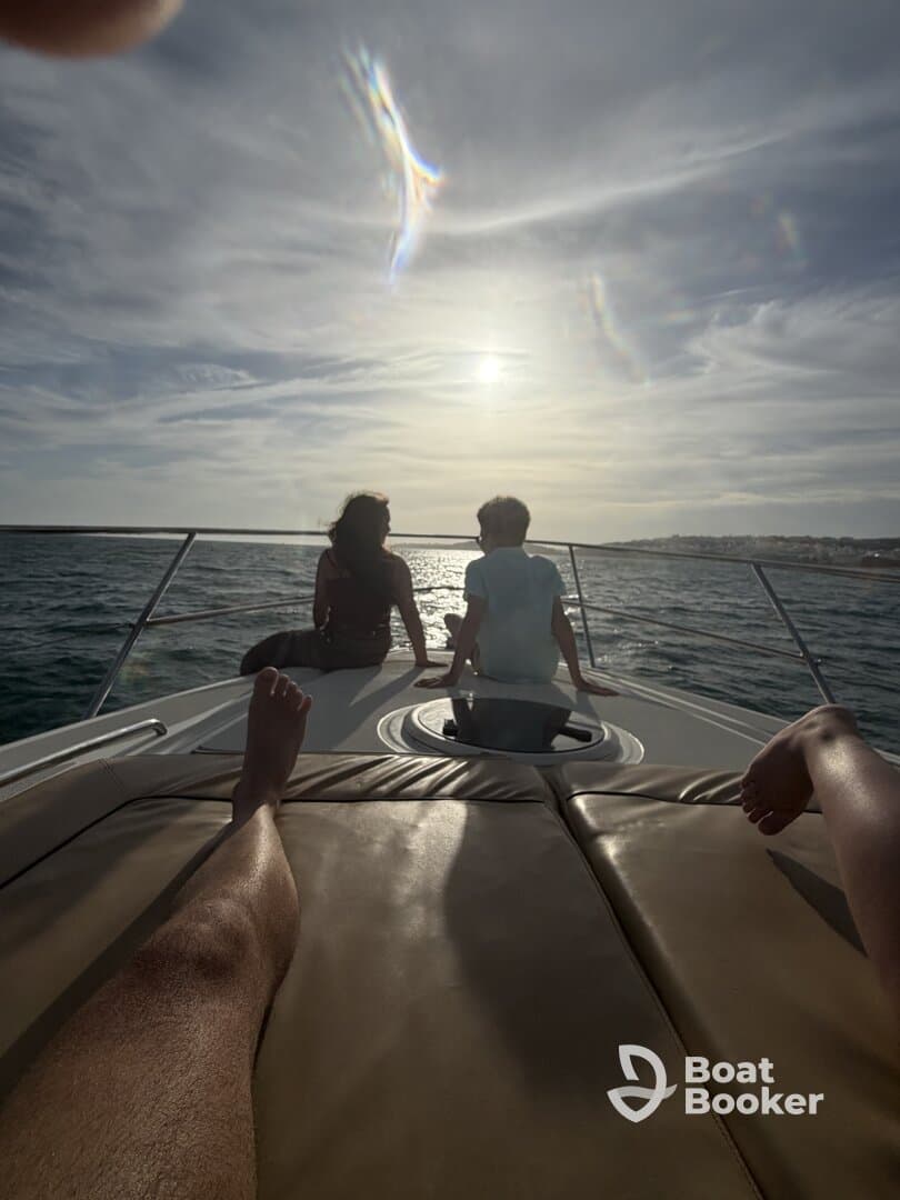 A couple enjoys a serene sunset view from the bow of a boat, creating a perfect moment for relaxation and connection on the water.