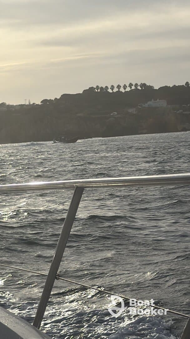 An unclear image of a boat in the distance, with a blurred view of the water and shoreline.